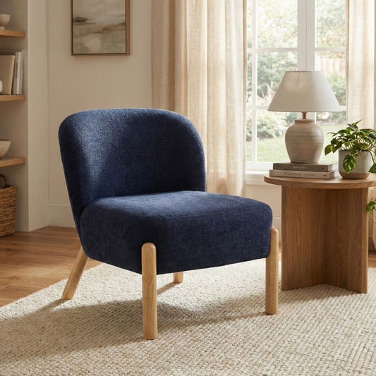 Blue armchair in a living room with wooden side table and window in background