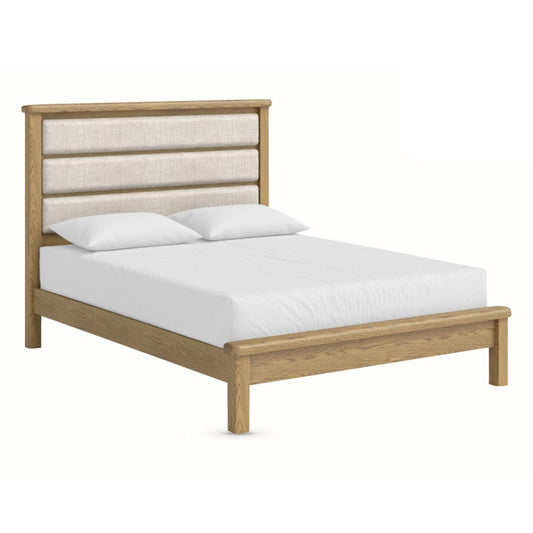 Wooden bed frame with upholstered headboard and white bedding on a white background