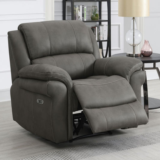 Gray recliner chair in a living room setting with a lamp and bookshelf in the background.