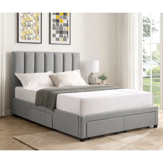 Grey upholstered bed with white bedding in a room with framed artwork on the wall.