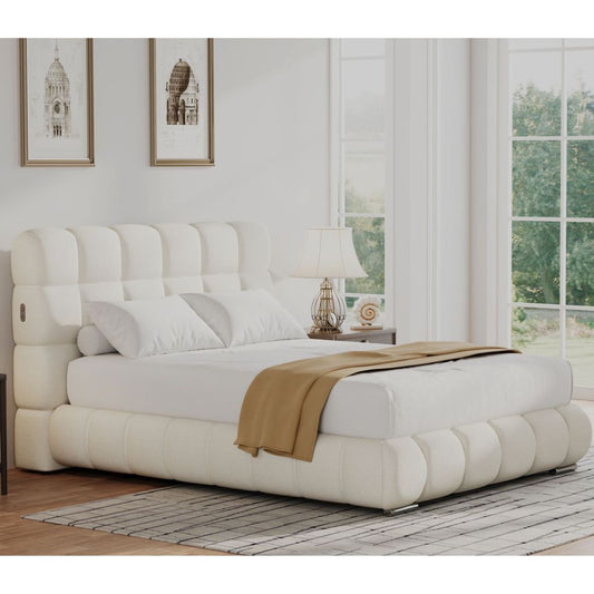 Natural boucle upholstered bed in a room with large windows and framed pictures on the wall.