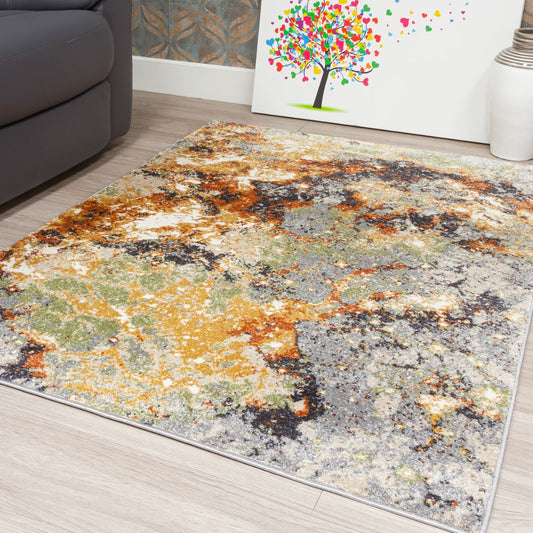 Multicolored abstract patterned rug on a wooden floor with a couch and wall art in the background.
