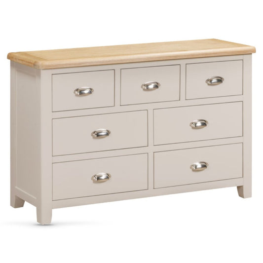 Wooden dresser with light grey drawers and a wooden top on a white background