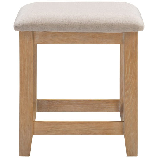 Wooden stool with a beige cushioned seat on a white background
