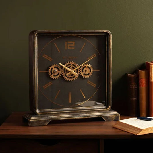 Decorative clock with gear design on a wooden surface against a dark green wall.