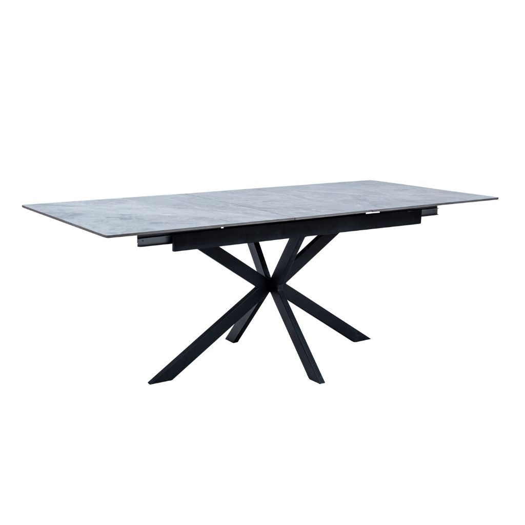 Modern dining table with marble top and black metal legs on a white background