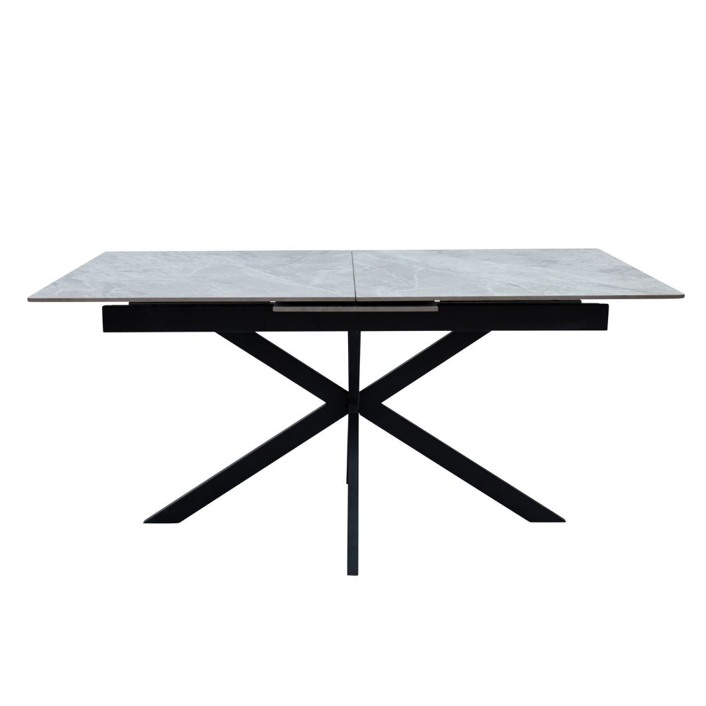 Dining table with marble-like top and black metal legs on a white background