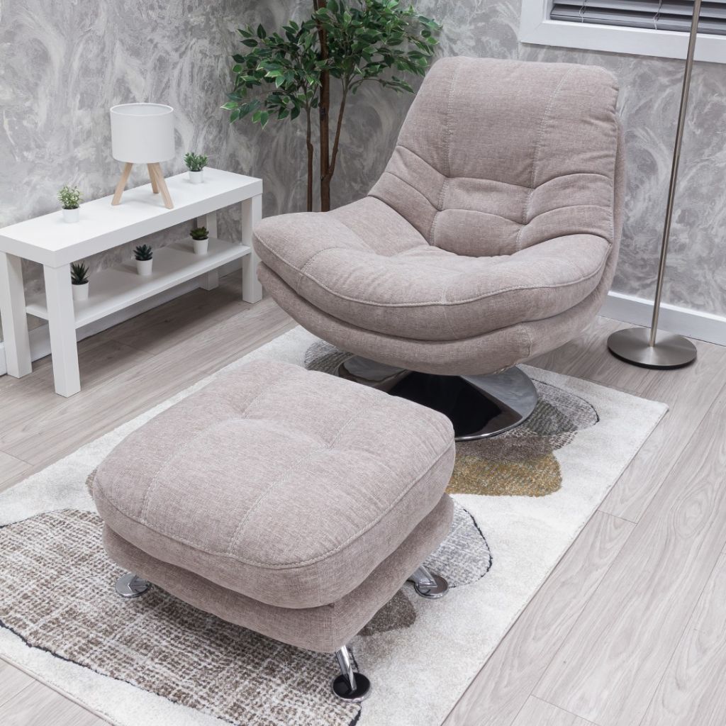 Beige armchair and ottoman set in a room with a white table and plant.