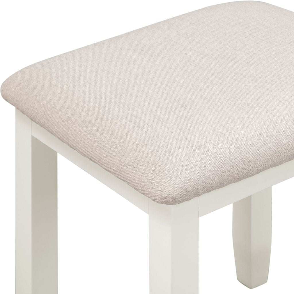 Ivory stool with a beige cushioned seat on a white background
