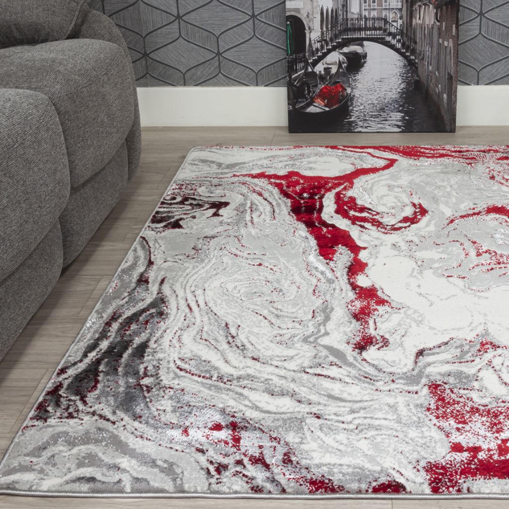 Abstract patterned rug with red, gray, and white colors in a living room setting.