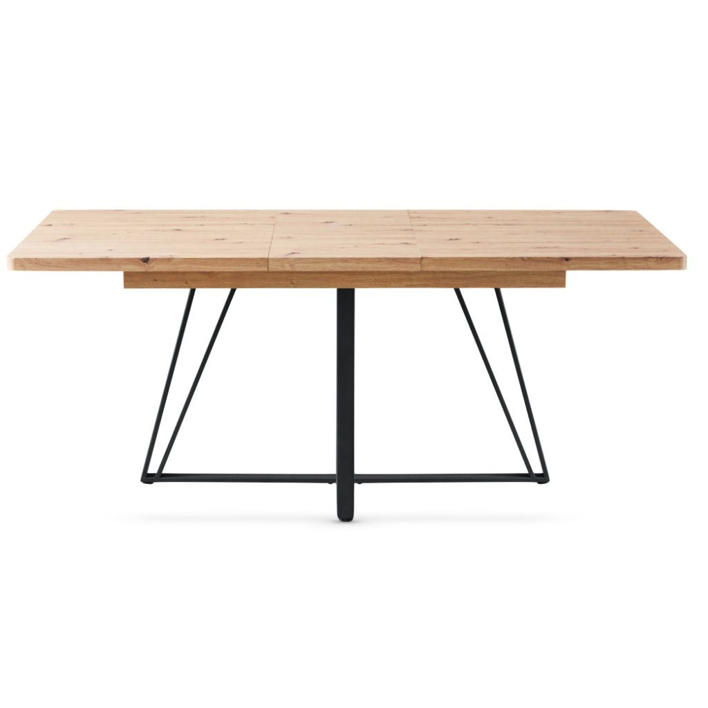 Wooden dining table with black metal legs on a white background