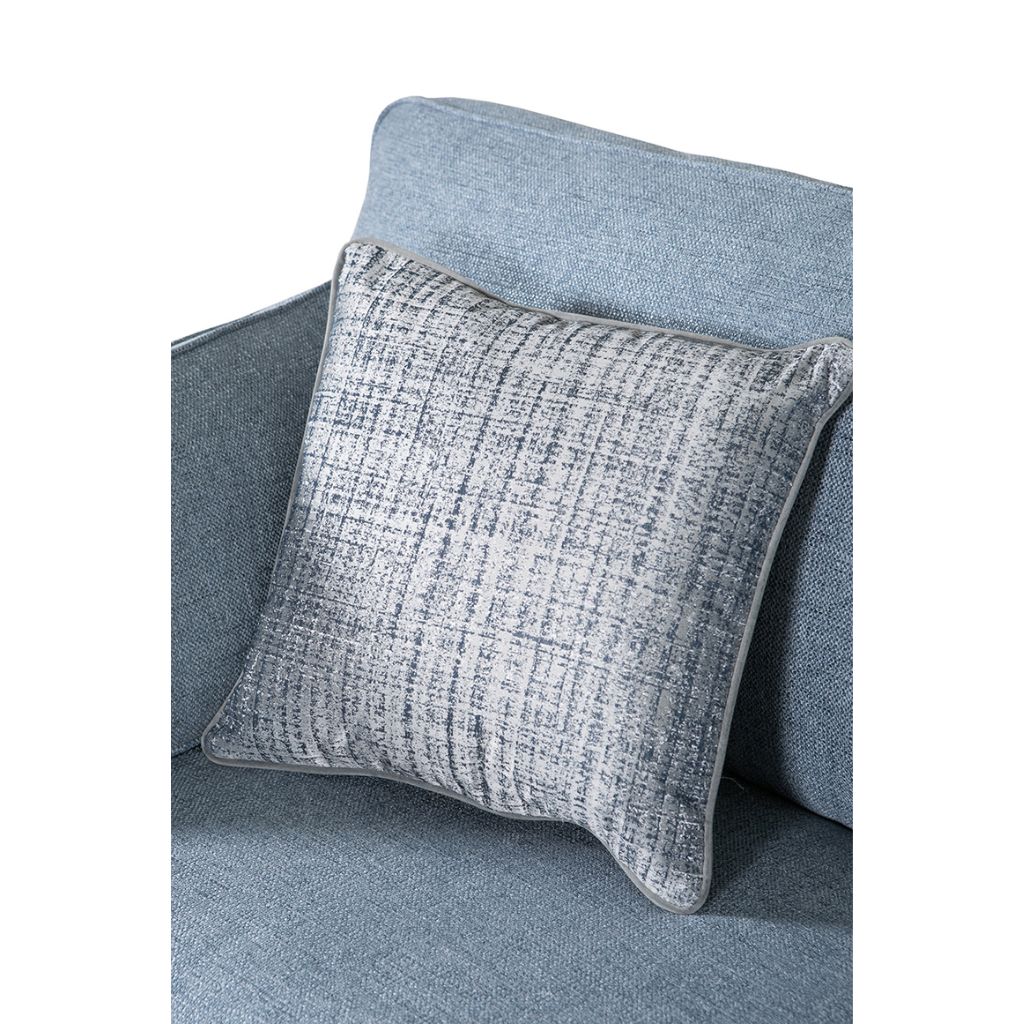 Textured gray pillow on a matching blue sofa