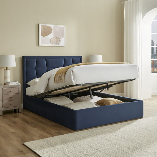Blue upholstered bed with storage compartment in a bedroom setting.