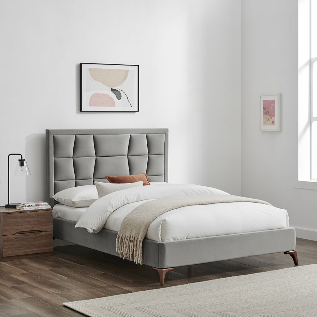 Gray upholstered bed with white bedding in a bedroom setting.