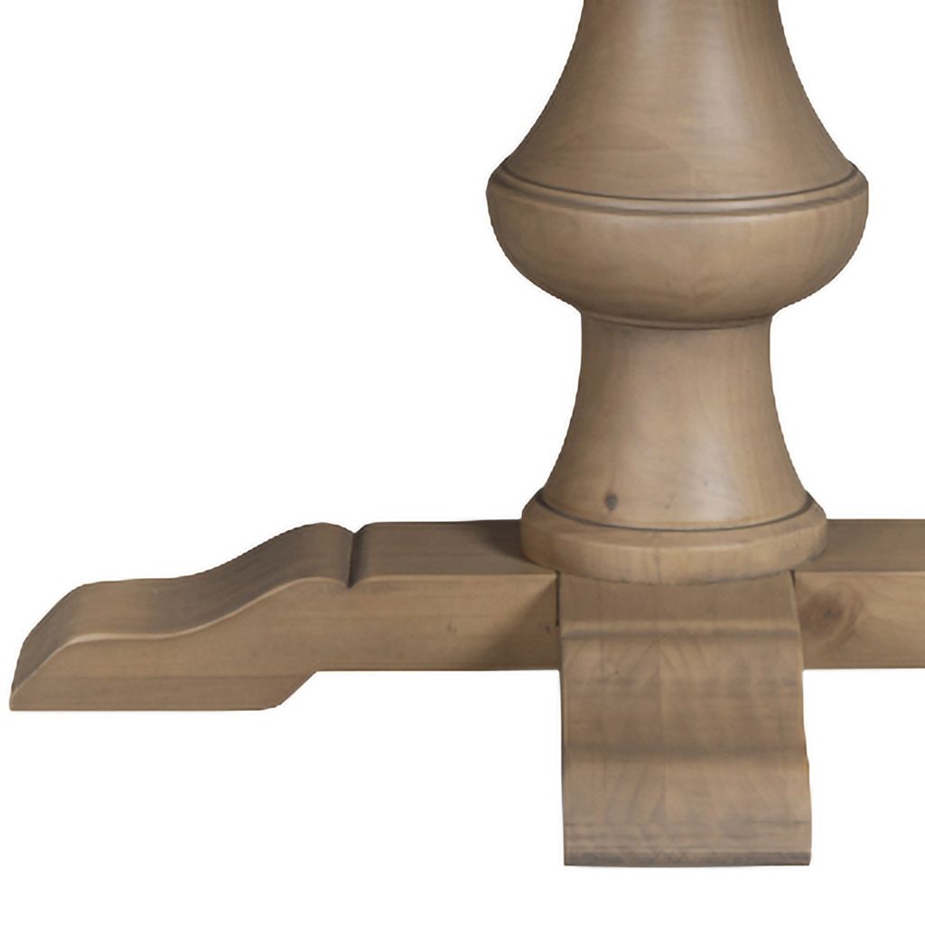 Close-up of a wooden table pedestal base and cross support leg in a rustic pine finish.