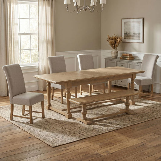 Dining room with wooden table, chairs, and bench on a patterned rug.