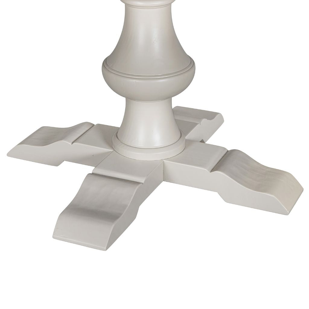 Close-up of a grey wooden table base with a decorative pedestal column and four curved legs .