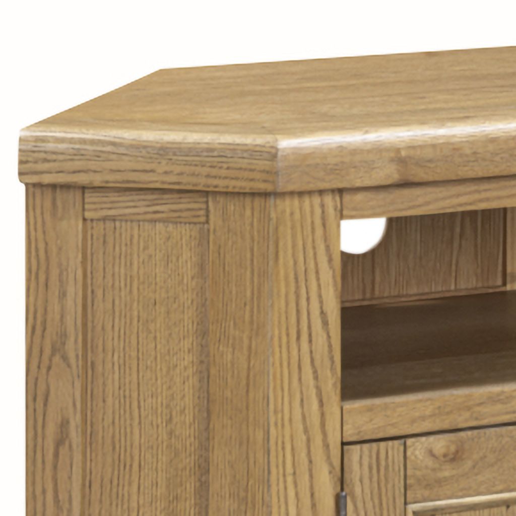 Close-up of a light oak wood TV stand showing the grain, top surface, side panel, and open shelf space.