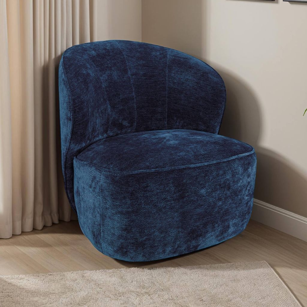 Blue velvet armchair in a room with beige curtains and carpet.