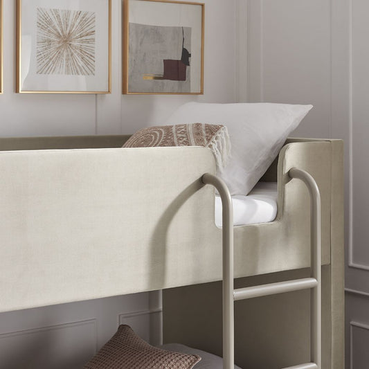 Bunk bed with white mattress and decorative pillows in a room with framed artwork on the wall.