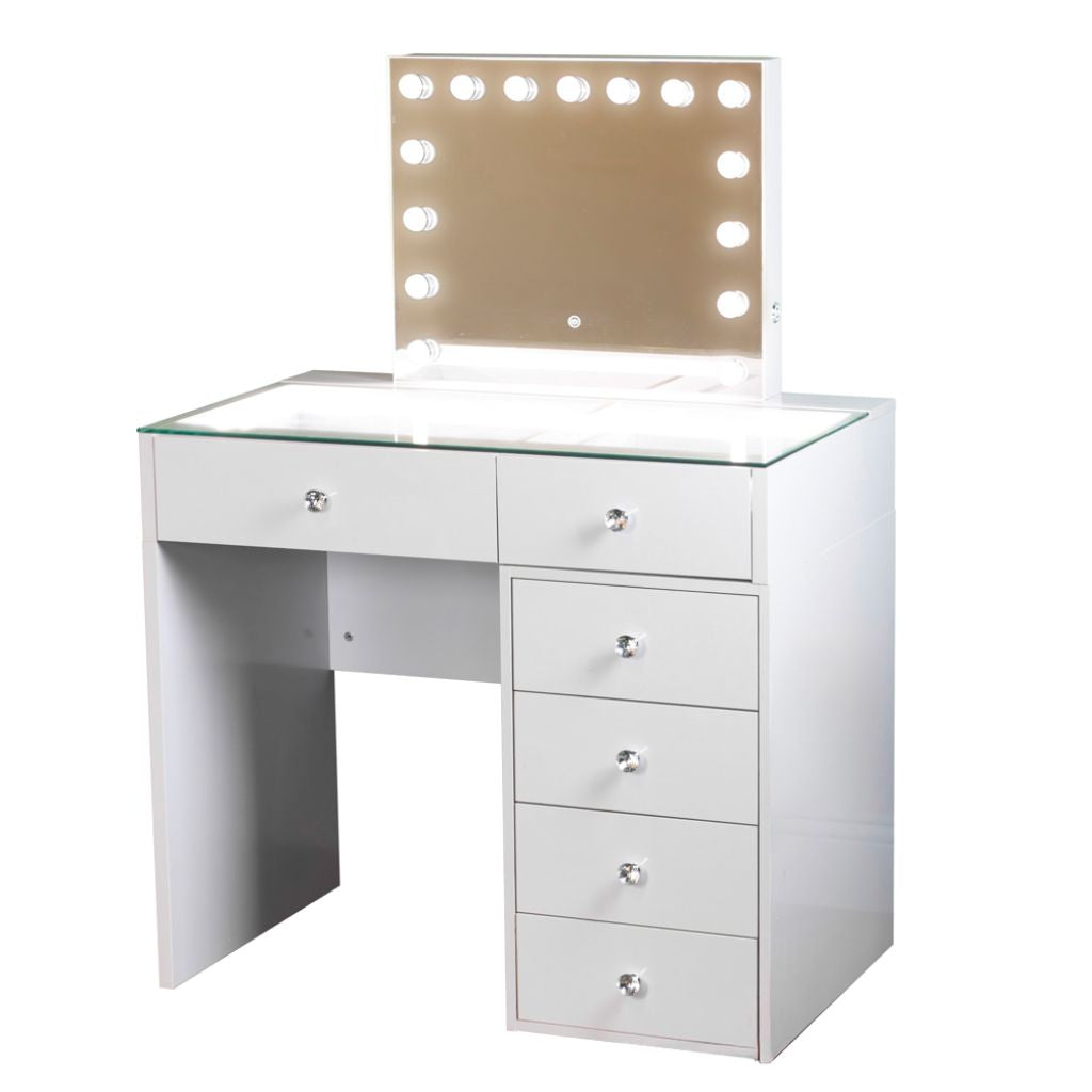 White dressing table with glass top and hollywood mirror with light bulbs.