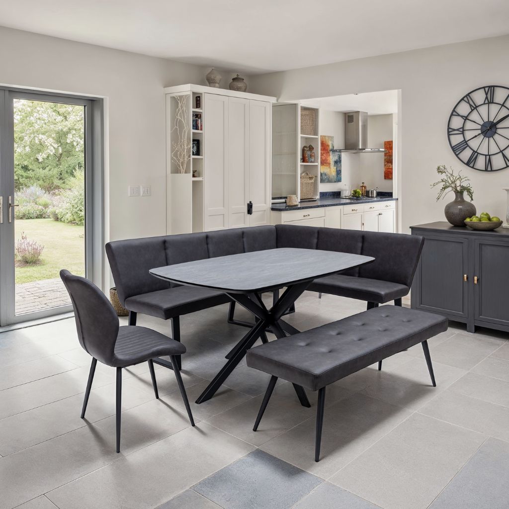 Modern dining area with gray furniture and a kitchen in the background.