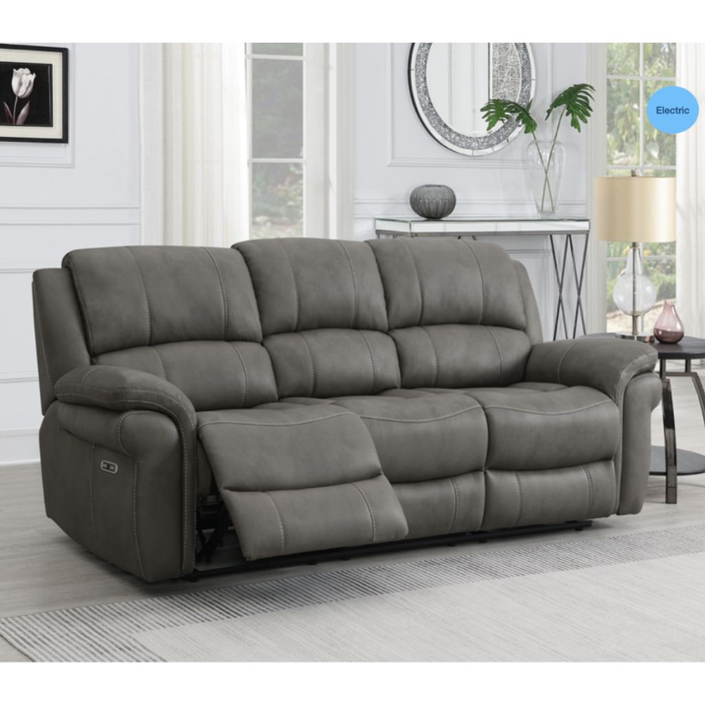 Gray reclining sofa in a living room setting with a lamp and decor items.