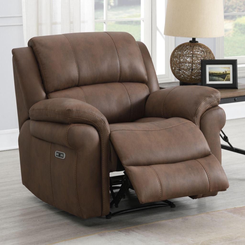 Brown fabric recliner chair in a living room setting with a lamp and window in the background.