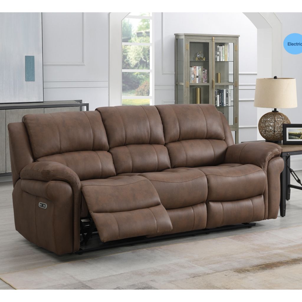 Brown fabric sofa in a living room setting with a lamp and bookshelf.