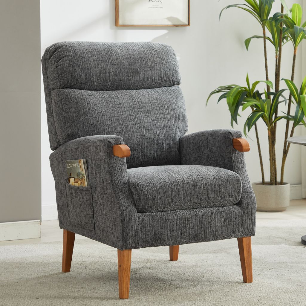 Gray armchair with wooden legs in a room with a plant and framed picture.