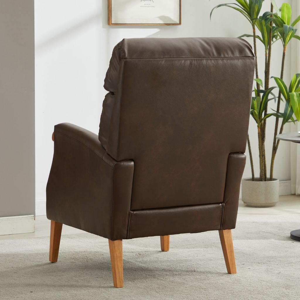 Brown pu armchair in a room with a plant and framed picture on the wall.
