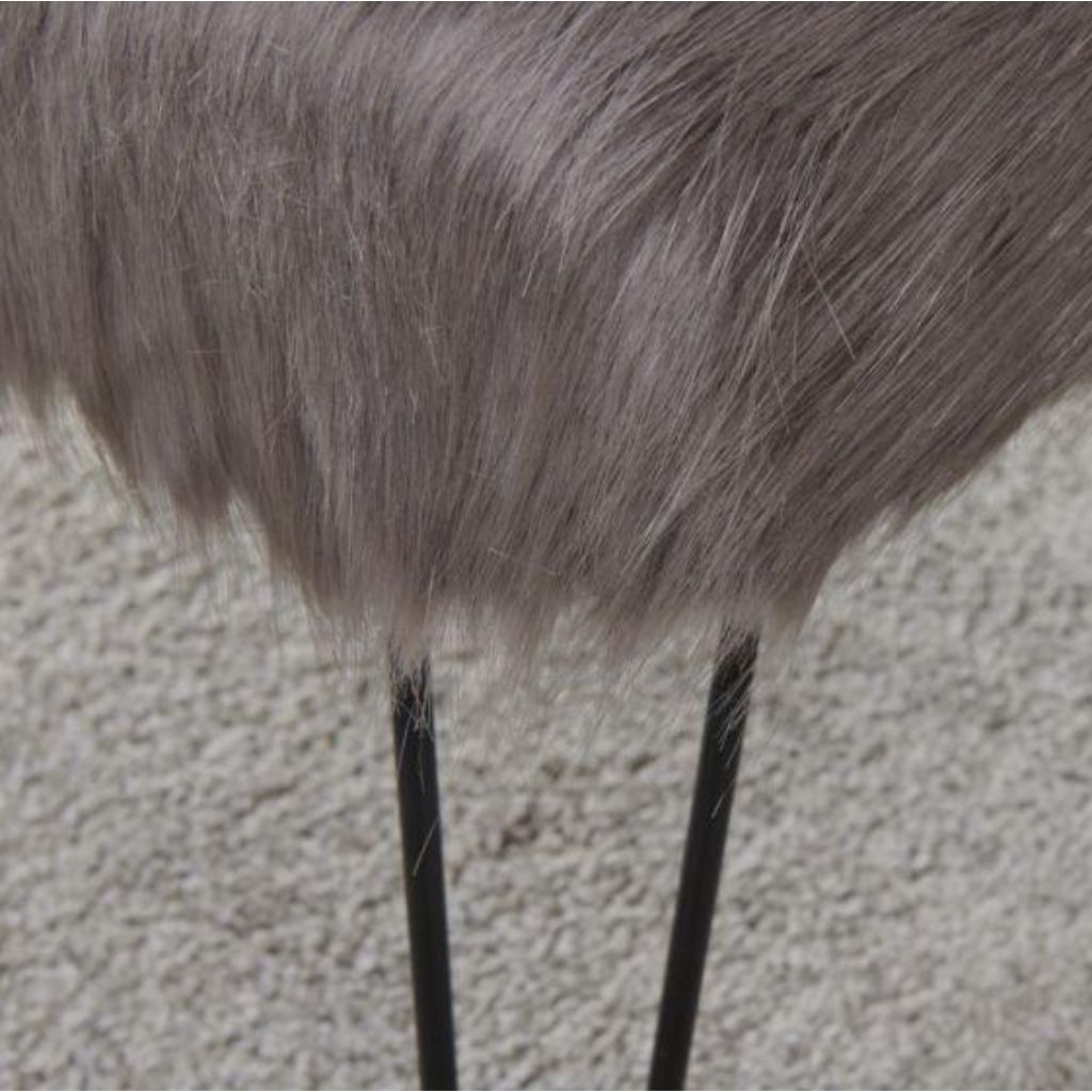 Close-up of a fur-covered object on a textured surface