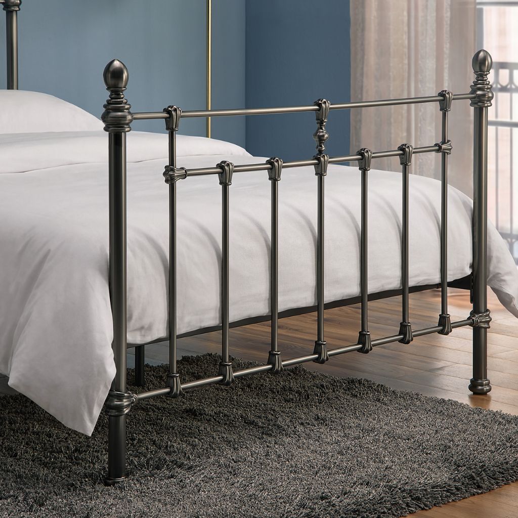 Metal bed frame with white bedding in a bedroom setting