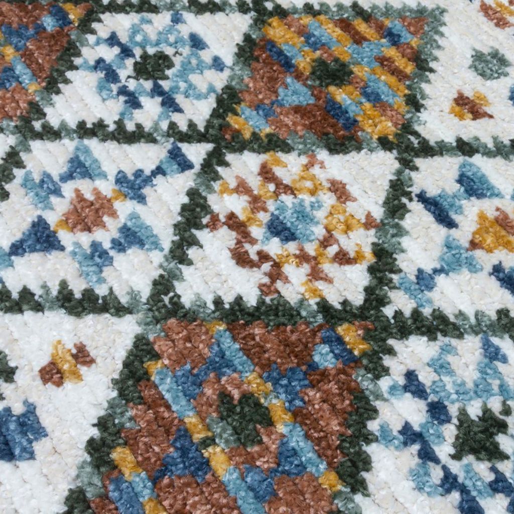 Close-up of a colorful geometric patterned rug with blue, brown, and green colors.
