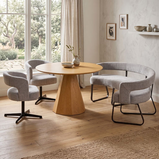 A round dining table in oak with grey dining bench and dining chairs seating up to 5 people