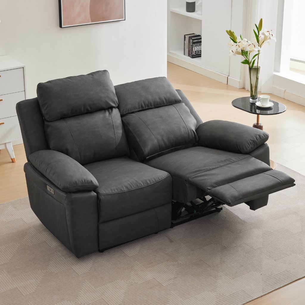 A dark grey two-seater recliner sofa with both cushions and the footrest extended.