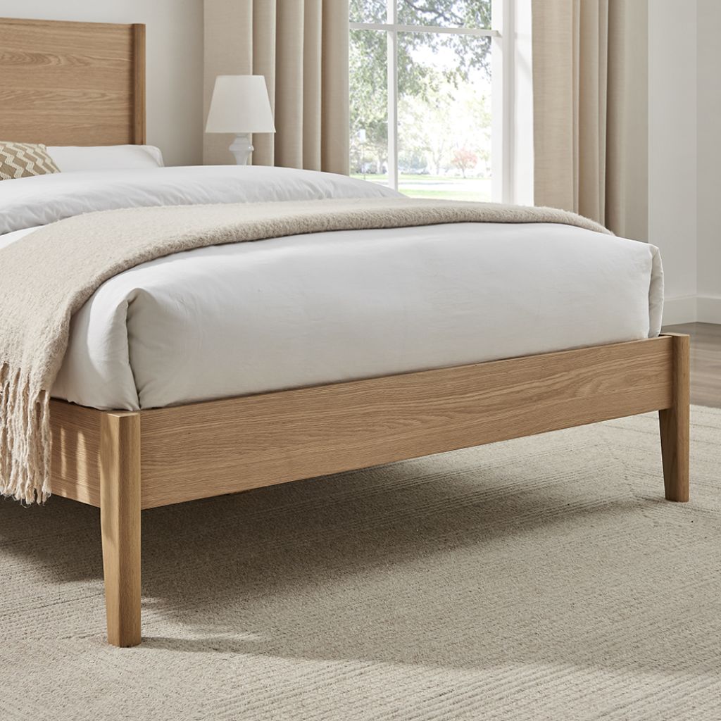 Wooden bed with white bedding in a bedroom setting