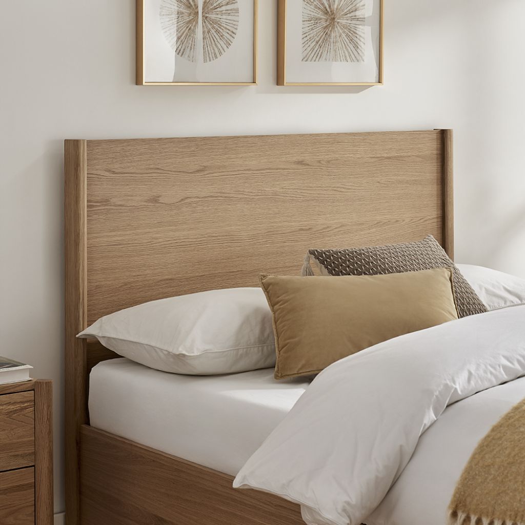 Wooden headboard with pillows on a bed in a bedroom setting