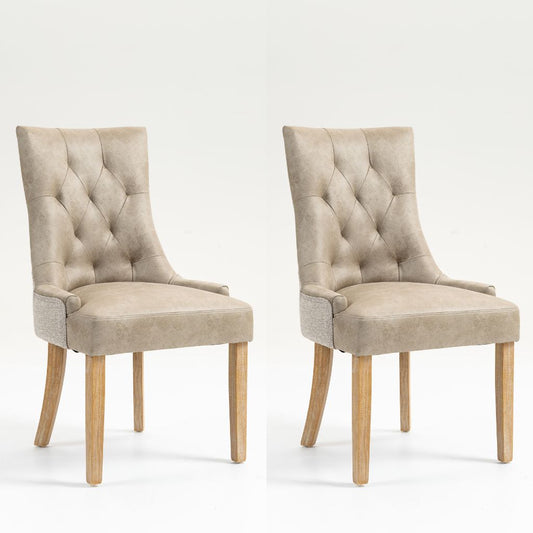 Two matching upholstered dining chairs with tufted backs, light beige fabric seats, and natural wood legs.