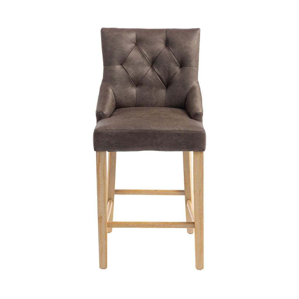 A high-back bar stool with a tufted, diamond-patterned backrest upholstered in dark brown PU, supported by four light natural wood legs and footrests.