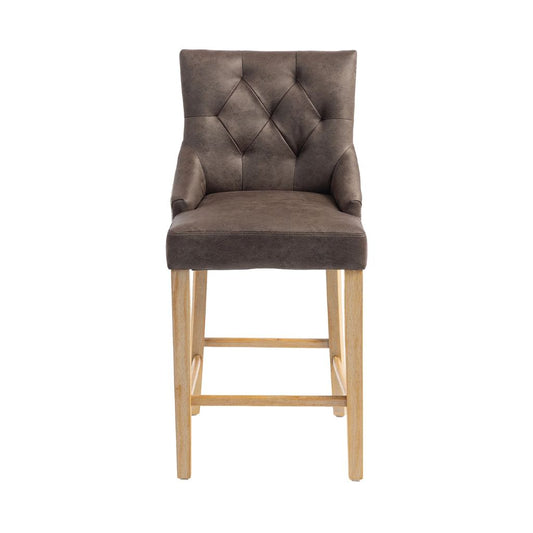 A high-back bar stool with a tufted, diamond-patterned backrest upholstered in dark brown PU, supported by four light natural wood legs and footrests.