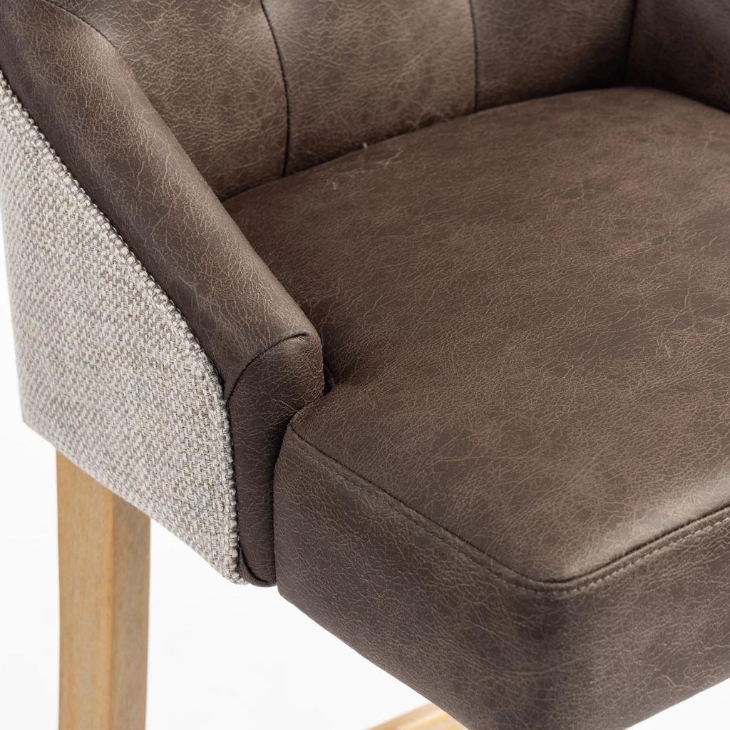 Close-up of a brown faux-leather upholstered chair seat and armrest
