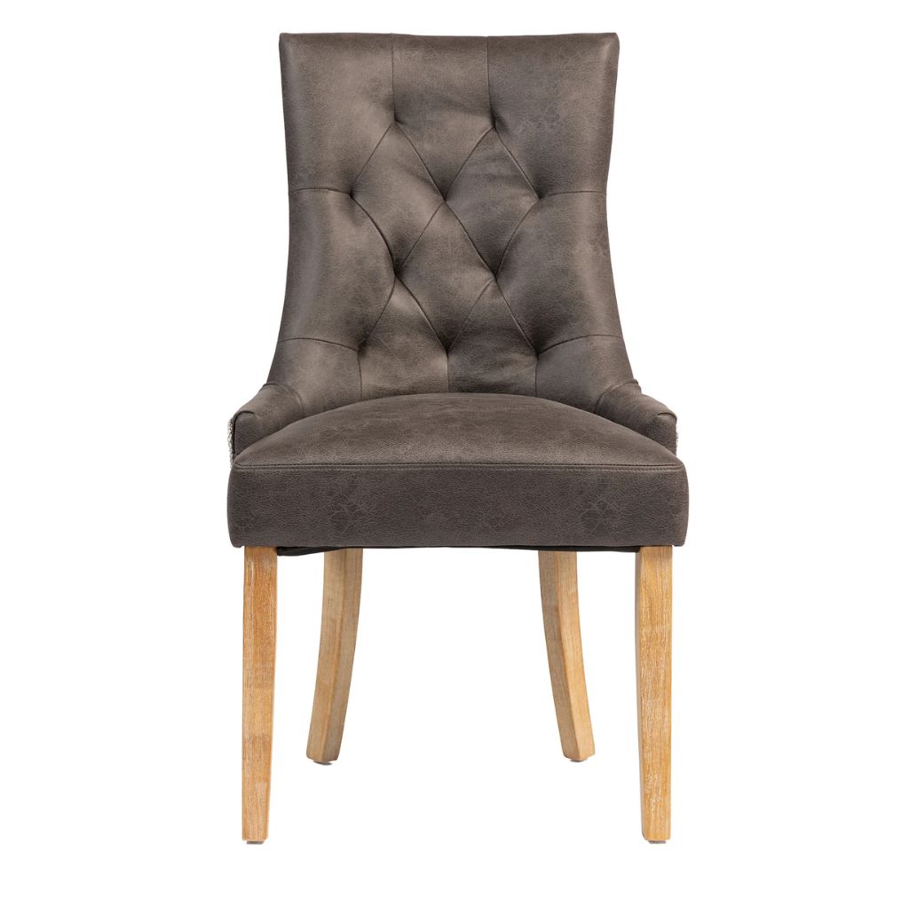A single upholstered dining chair with a tall, winged back, diamond tufted button detailing, and light natural wood legs.
