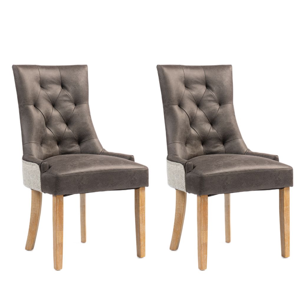 Two matching upholstered dining chairs with tufted backs, light wood legs and light gray side panels