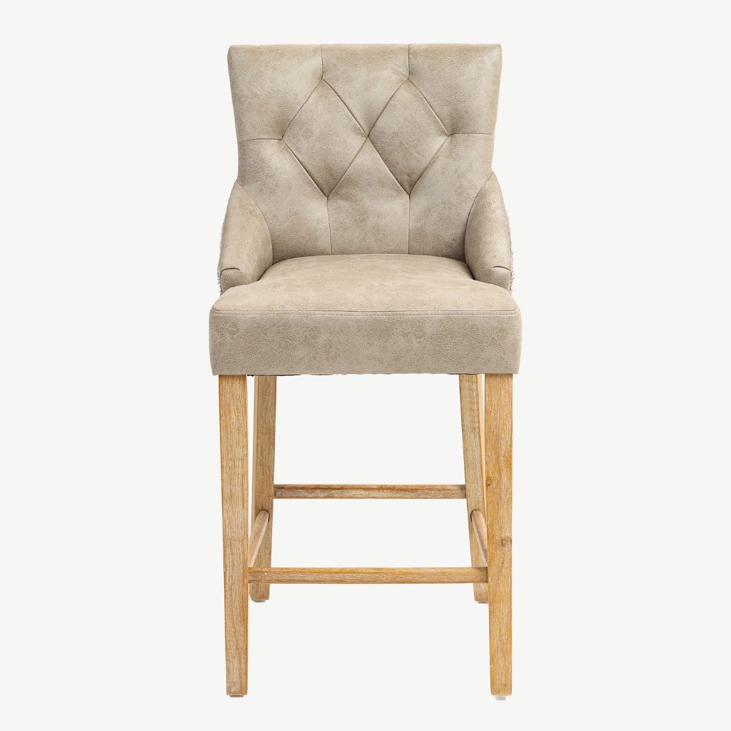 A single upholstered bar stool with a tufted backrest, padded seat, rolled arms, and light natural wood legs.