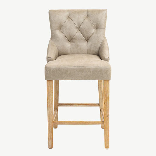 A single upholstered bar stool with a tufted backrest, padded seat, rolled arms, and light natural wood legs.