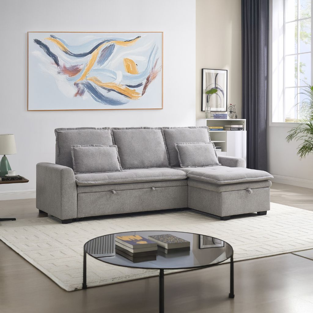 Grey sectional sofa in a living room with abstract art and a coffee table.