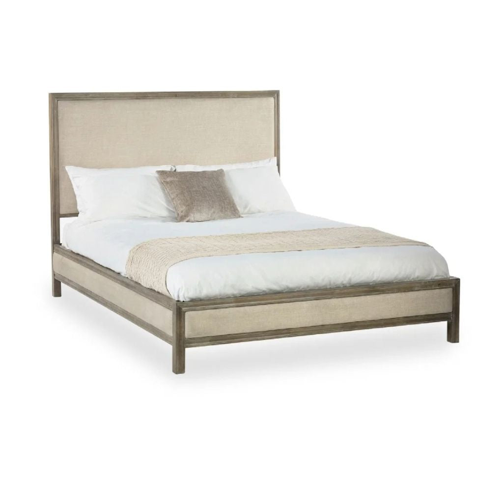 A modern platform bed with a tall upholstered headboard and matching upholstered footboard, the frame is a limed oak wood, and the upholstery is a ivory fabric.
