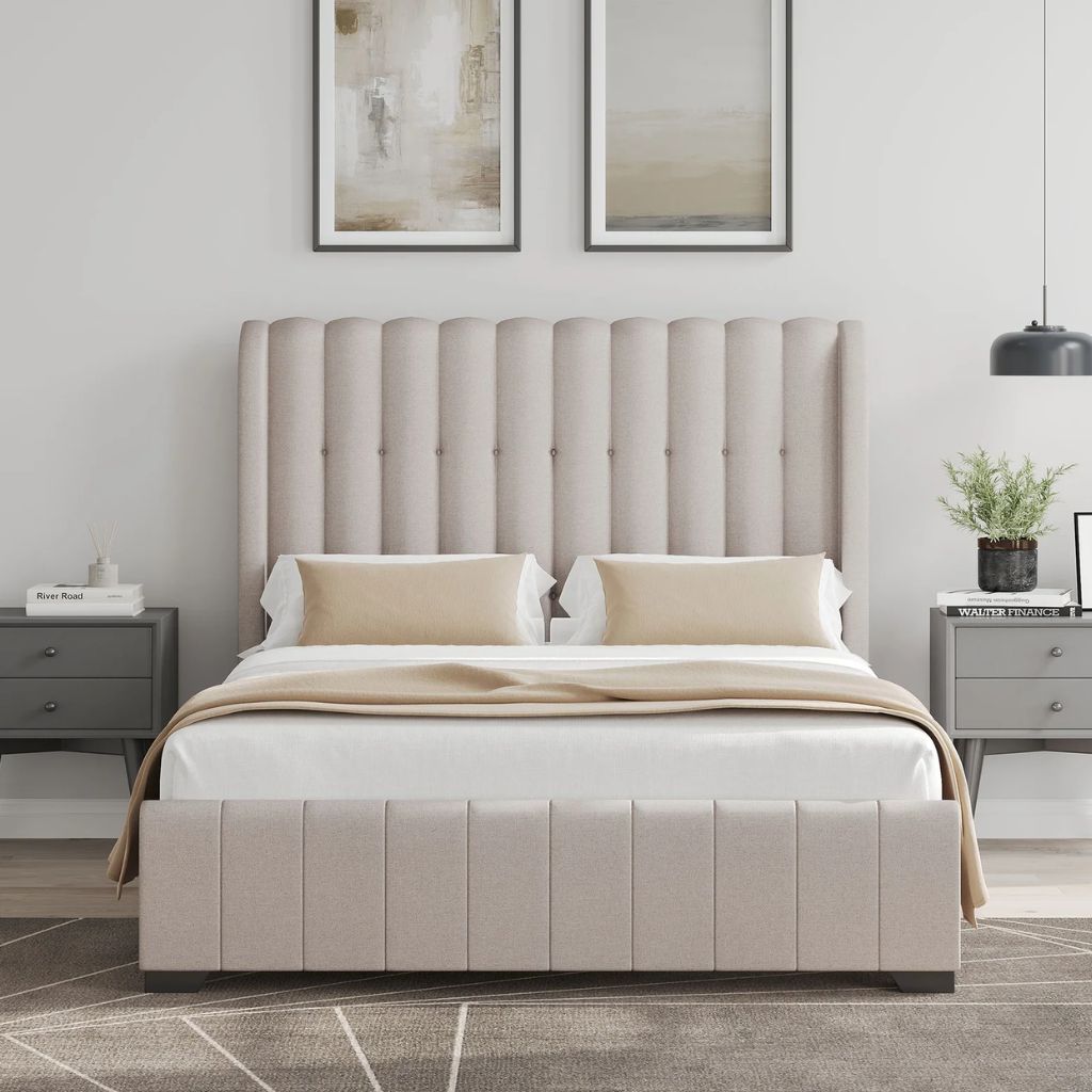 Beige upholstered bed in a bedroom setting with side tables and artwork on the wall.
