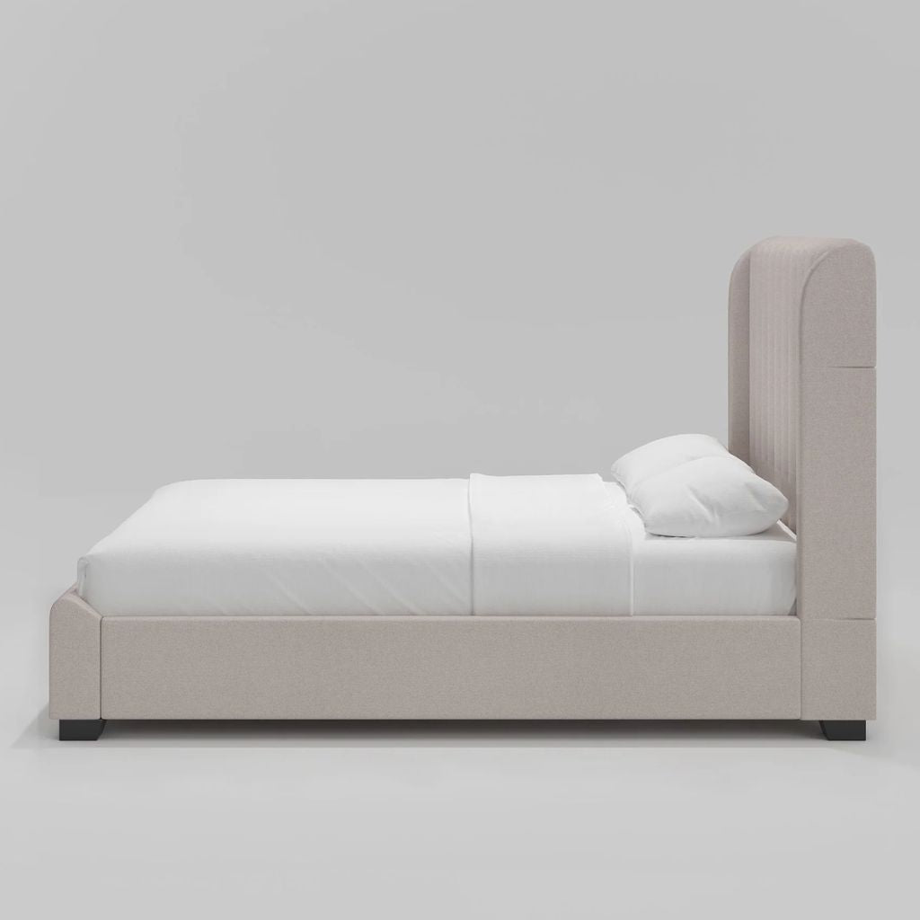 Beige upholstered bed with white bedding on a gray background